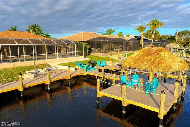 view of dock with a lanai, a water view, and boat lift