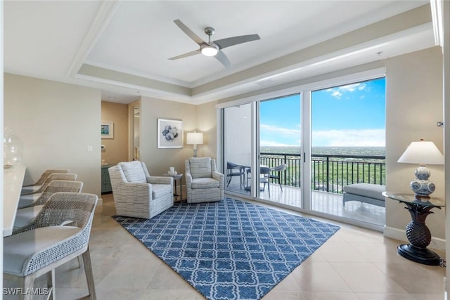 tiled living room with a tray ceiling, a ceiling fan, and baseboards