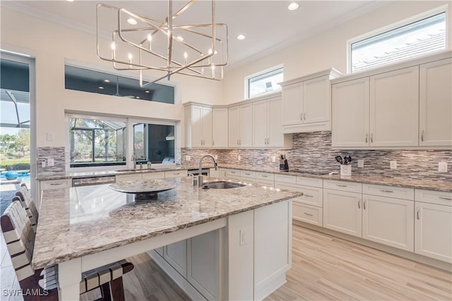 kitchen with crown molding, a sink, and backsplash