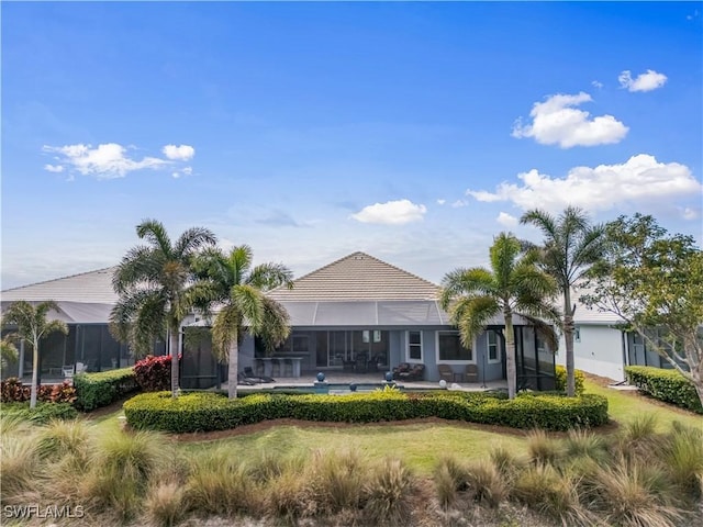 rear view of property with an outdoor pool, a lanai, a lawn, and a patio