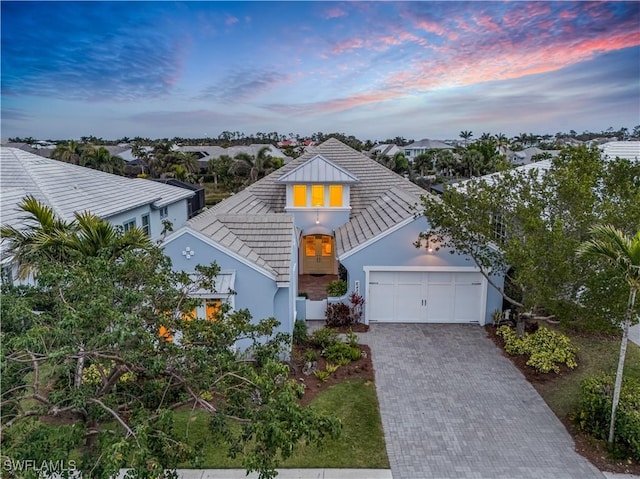 view of front of house featuring a garage, decorative driveway, and stucco siding