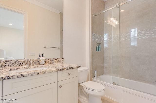 bathroom with shower / bath combination with glass door, vanity, and toilet