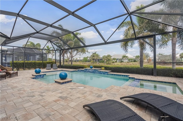 view of swimming pool featuring glass enclosure, a pool with connected hot tub, and a patio area