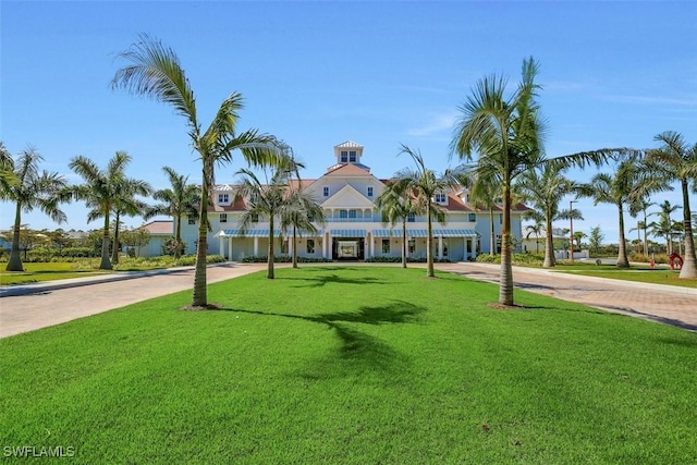 surrounding community with decorative driveway and a lawn