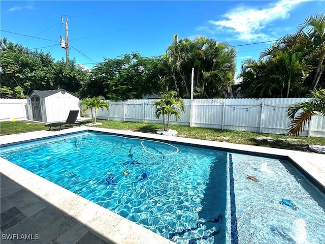 view of pool featuring a storage shed, an outdoor structure, a fenced backyard, and a fenced in pool