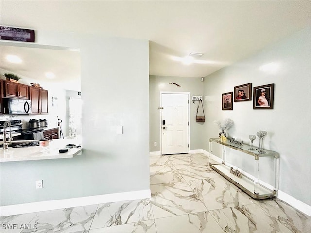 foyer entrance featuring marble finish floor and baseboards