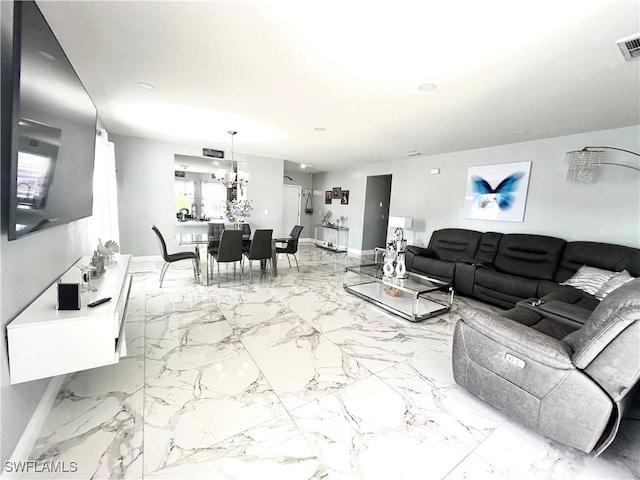 living room featuring marble finish floor, baseboards, visible vents, and a chandelier