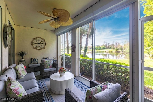 sunroom / solarium featuring a water view and a ceiling fan