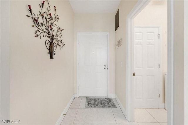 doorway featuring light tile patterned flooring, visible vents, and baseboards