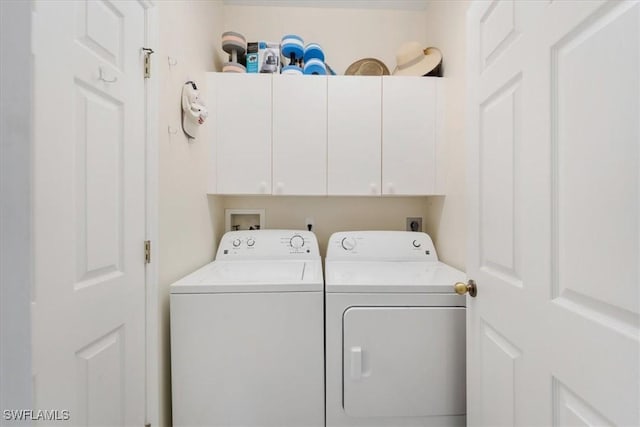 washroom featuring cabinet space and washing machine and dryer