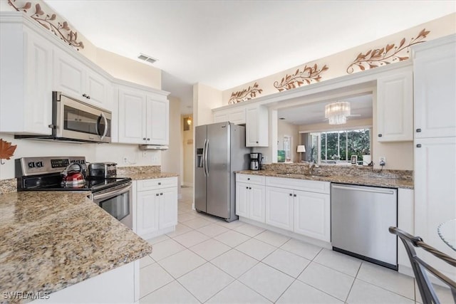 kitchen featuring light stone counters, a sink, visible vents, white cabinets, and appliances with stainless steel finishes