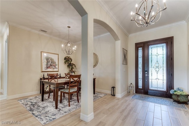 foyer featuring a chandelier, arched walkways, visible vents, and light wood-style floors