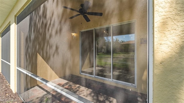 details featuring ceiling fan and stucco siding