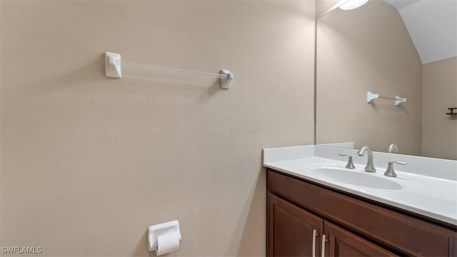 bathroom with lofted ceiling and vanity