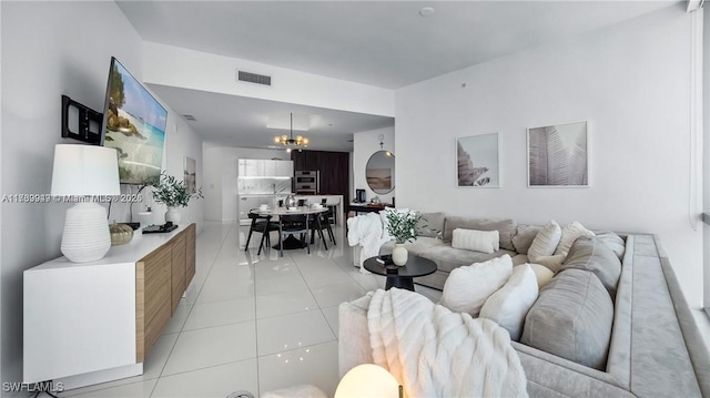 living room with visible vents, an inviting chandelier, and light tile patterned flooring