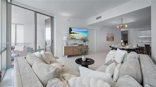 living room with a wall of windows, light tile patterned flooring, a notable chandelier, and visible vents