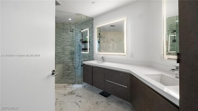 full bathroom with a stall shower, marble finish floor, a sink, and double vanity