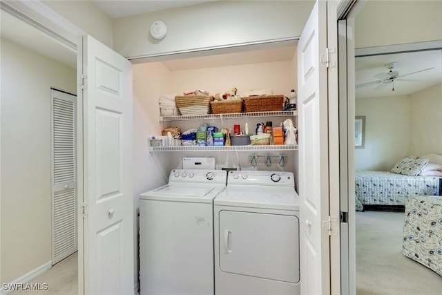 laundry room with light colored carpet, laundry area, a ceiling fan, baseboards, and independent washer and dryer