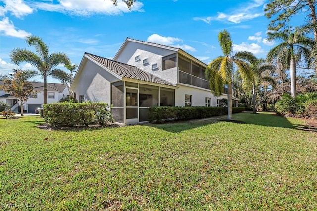 back of property featuring a lawn and a sunroom