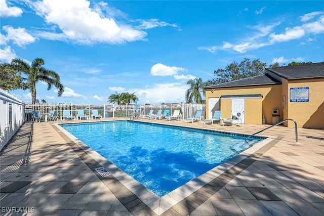 pool with a patio area and fence