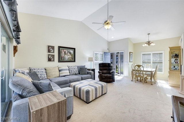 living room with high vaulted ceiling, light carpet, and ceiling fan with notable chandelier