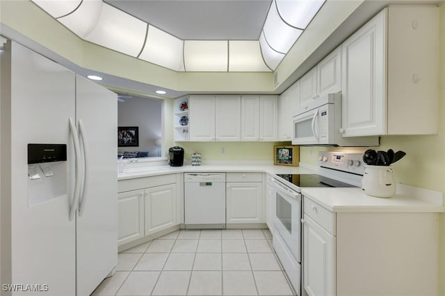 kitchen featuring light tile patterned floors, white appliances, and white cabinetry