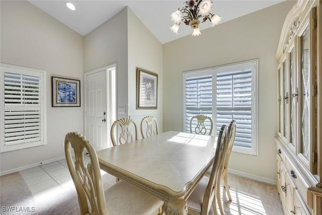 dining space featuring light carpet, baseboards, and an inviting chandelier