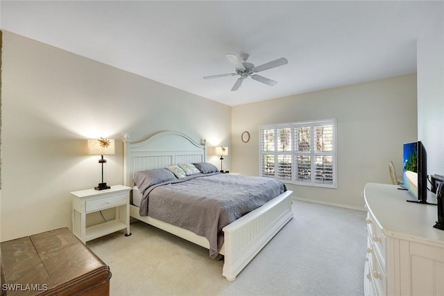 bedroom featuring light carpet, a ceiling fan, and baseboards