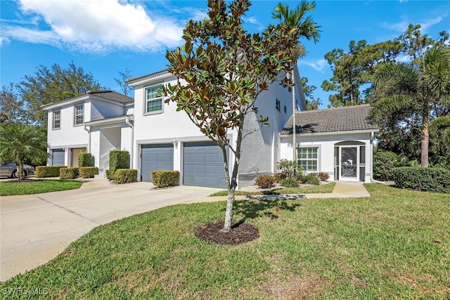 view of front facade with driveway, stucco siding, an attached garage, and a front yard