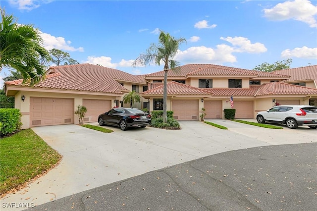 view of front facade featuring stucco siding, concrete driveway, an attached garage, and a tiled roof