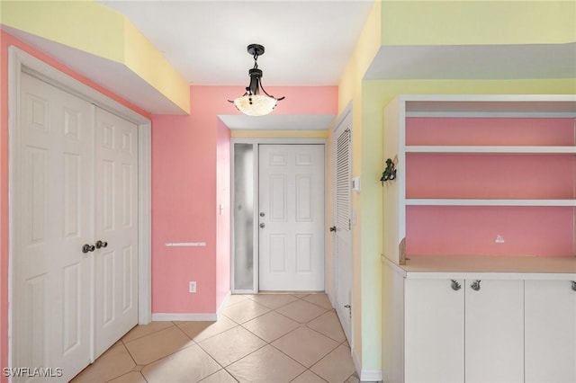 foyer featuring light tile patterned floors and baseboards