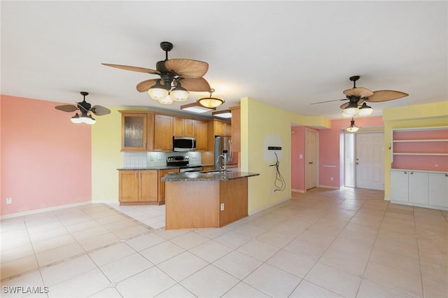 kitchen with decorative backsplash, stainless steel appliances, brown cabinetry, glass insert cabinets, and baseboards