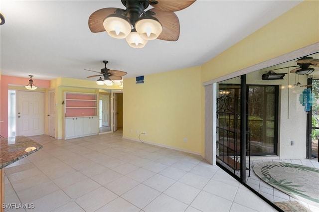 interior space with tile patterned floors, baseboards, and ceiling fan