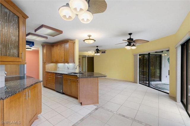 kitchen featuring tasteful backsplash, a peninsula, brown cabinetry, and a sink