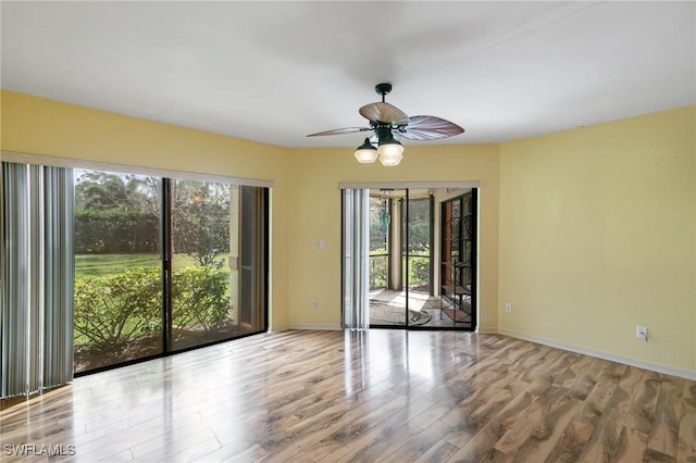 unfurnished room featuring ceiling fan, baseboards, and wood finished floors