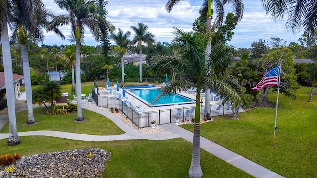 community pool with fence and a yard