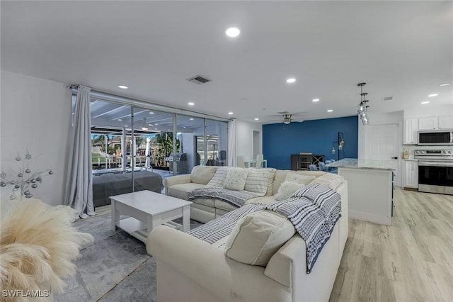 living area featuring a ceiling fan, recessed lighting, light wood-style floors, and visible vents