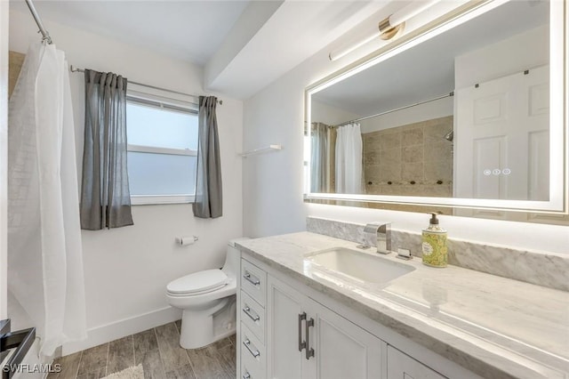 bathroom featuring vanity, wood finished floors, baseboards, curtained shower, and toilet