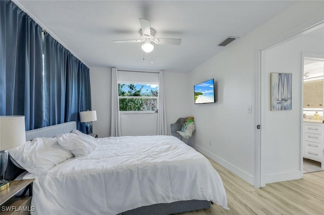 bedroom with visible vents, ensuite bathroom, a ceiling fan, light wood-style floors, and baseboards