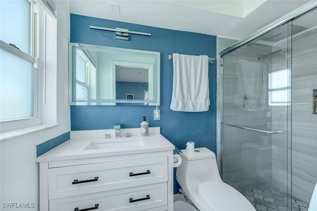 full bathroom featuring a shower stall, vanity, and toilet