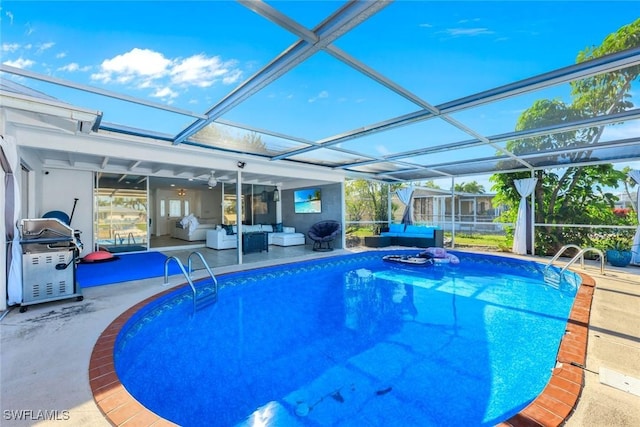 pool featuring glass enclosure, a patio, and an outdoor hangout area