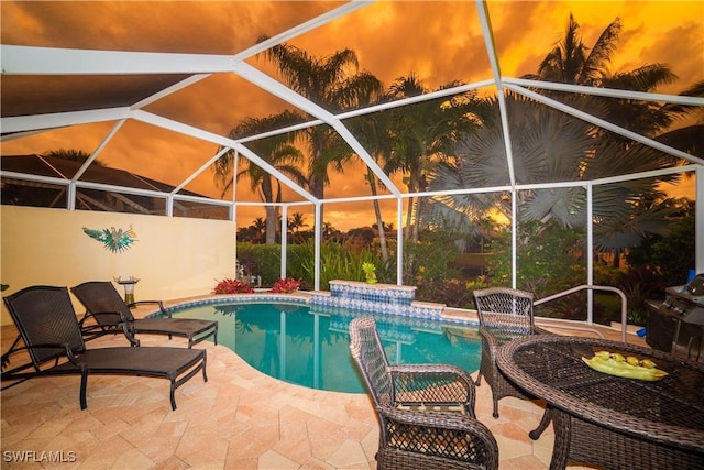 outdoor pool with glass enclosure and a patio