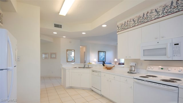 kitchen featuring white appliances, visible vents, a peninsula, a sink, and recessed lighting