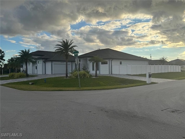 view of front of property featuring driveway, a front yard, and fence