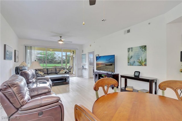 living area with light wood-style floors, visible vents, and ceiling fan