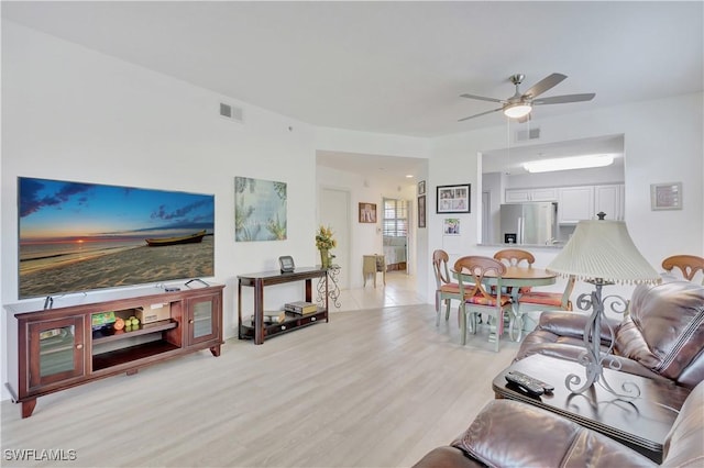 living area with a ceiling fan, visible vents, and light wood-style flooring