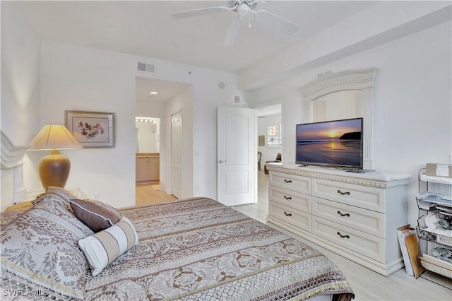 bedroom featuring ensuite bath, visible vents, and a ceiling fan