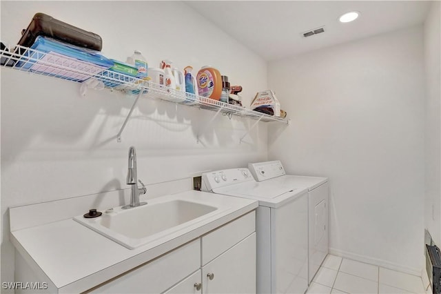 clothes washing area featuring recessed lighting, cabinet space, washing machine and dryer, light tile patterned flooring, and a sink