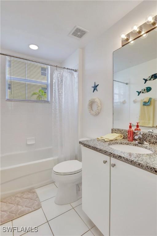 bathroom featuring toilet, shower / bath combo, visible vents, and tile patterned floors