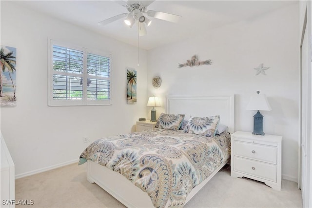 bedroom featuring light carpet, baseboards, and a ceiling fan